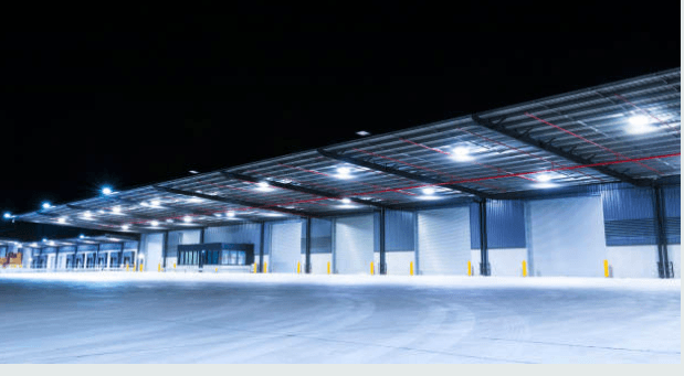 A spacious warehouse glowing with lights during the night