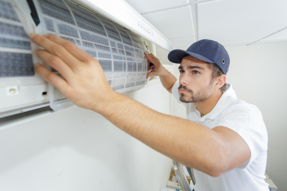 A man diligently working on an air conditioning system