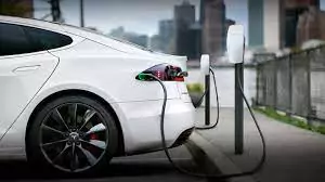 White electric car charging at an urban charging station.