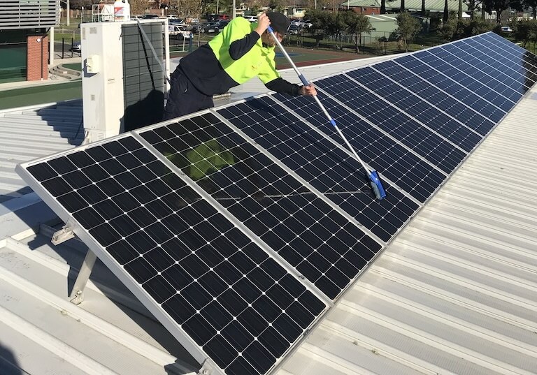 man cleaning solar panel